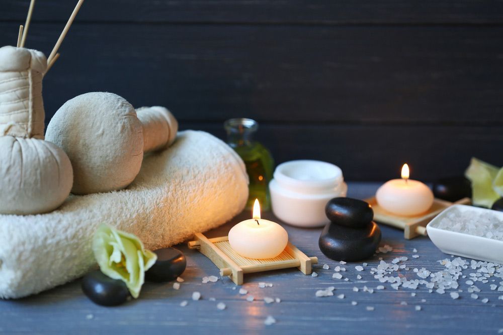 Table Topped With Towels Candles And Rocks For Spa Treatment — Paradiso Skin & Beauty Studio in Byron Bay, NSW