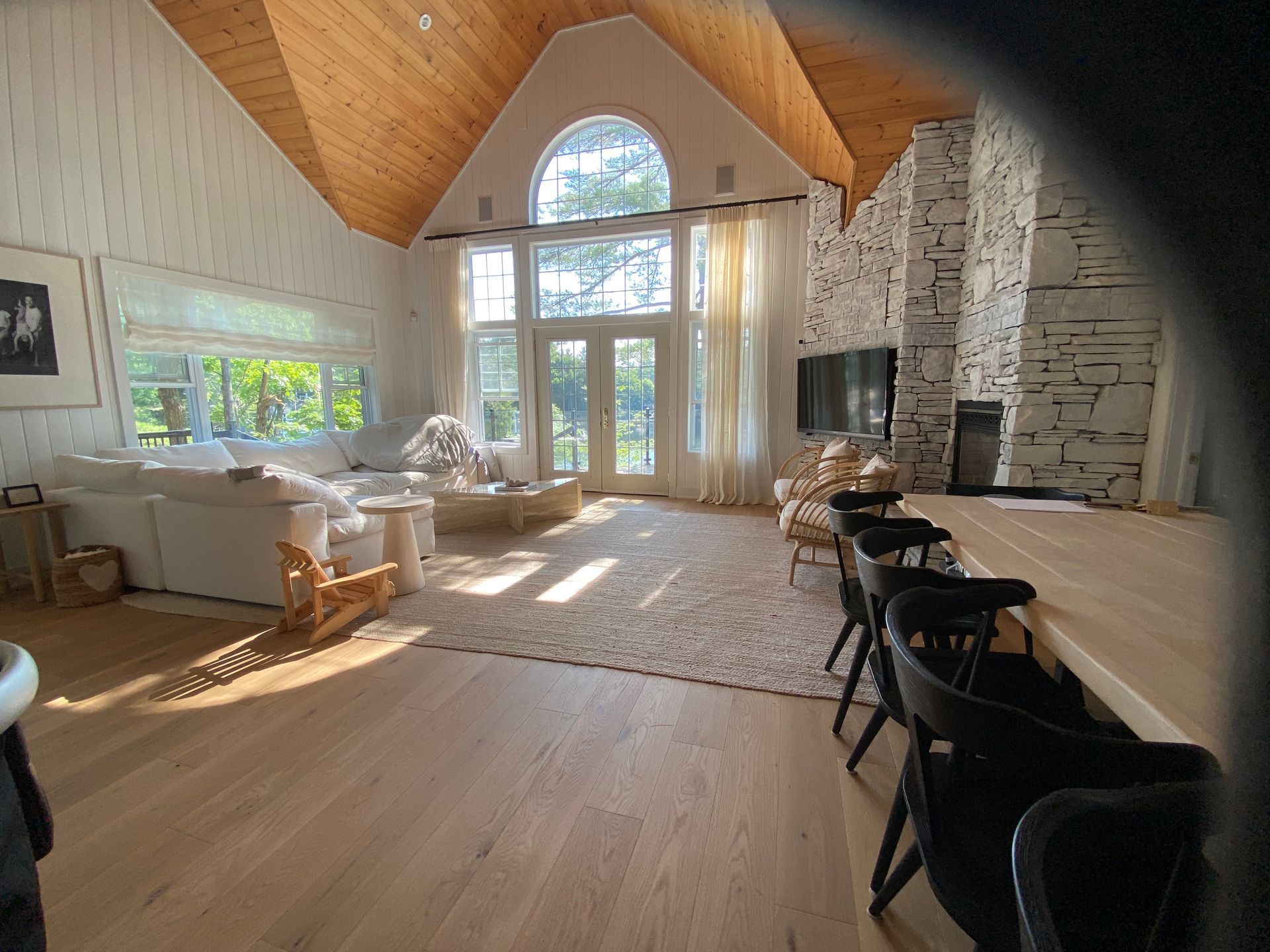 A living room with a vaulted ceiling and a fireplace.