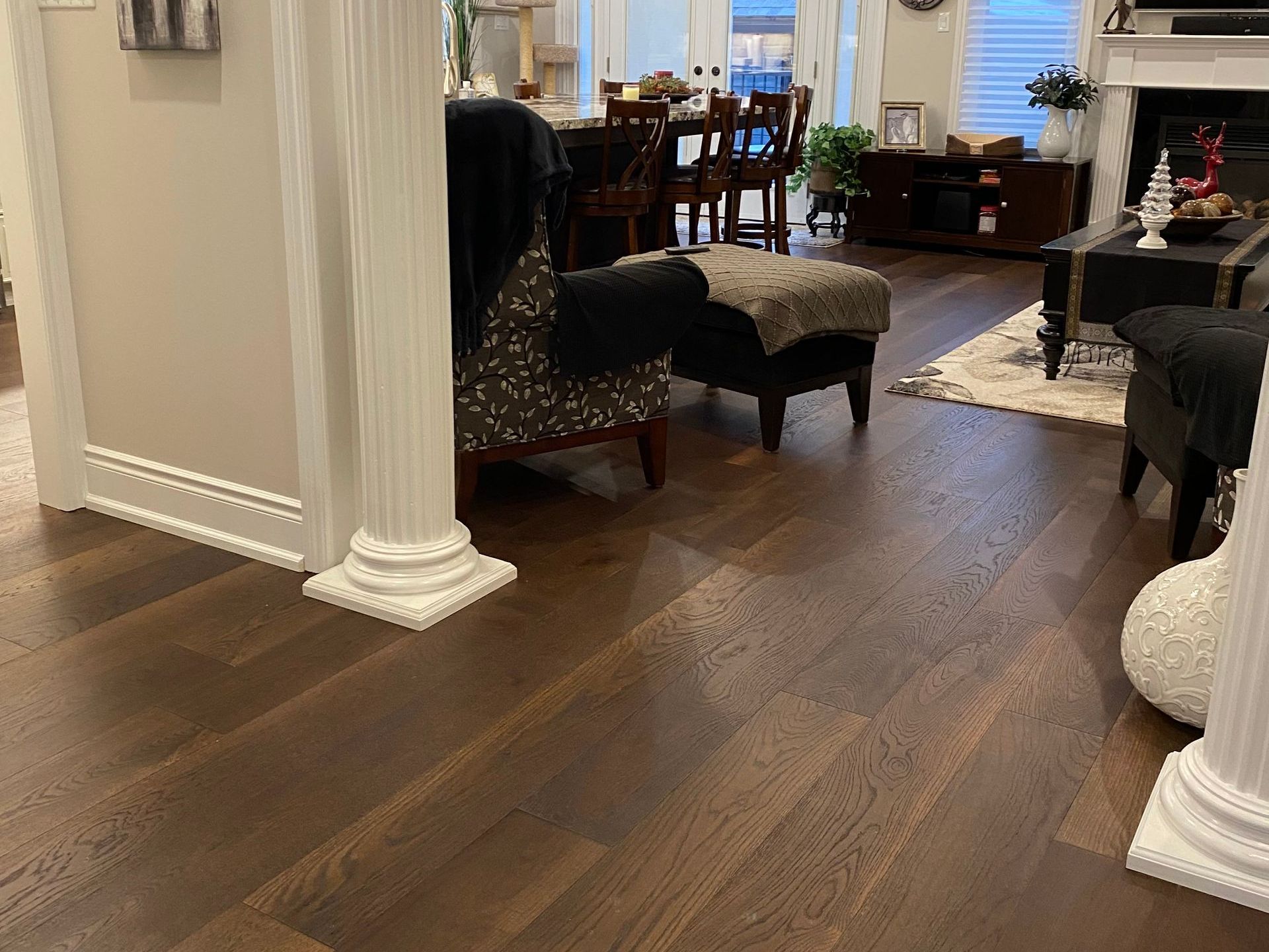 A living room with hardwood floors and white columns