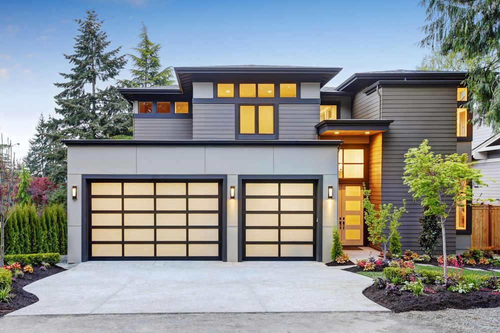 A modern house with two garage doors and a driveway.