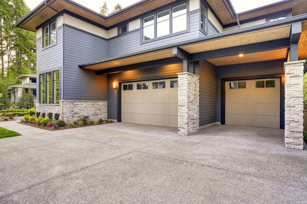 A large house with two garage doors and a driveway.