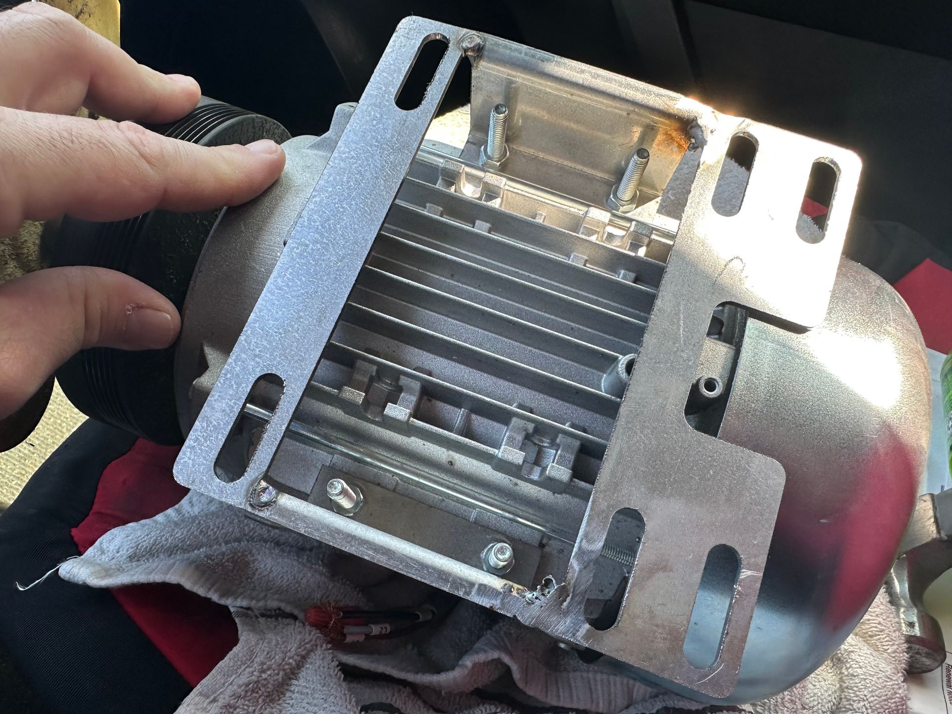 A person is holding a metal object with holes in it