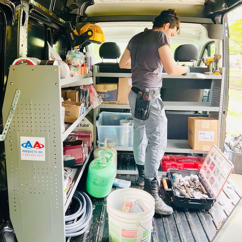 A man is standing in the back of a van.