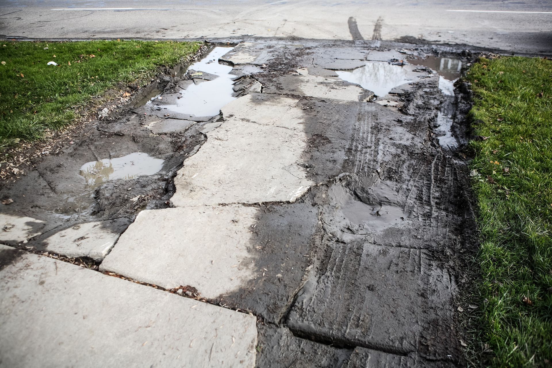 A broken and damaged driveway. A broken and damaged driveway.