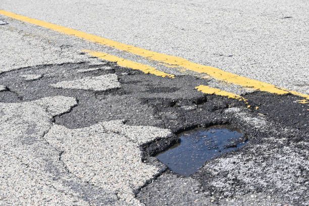 A wet pothole on the pavement.