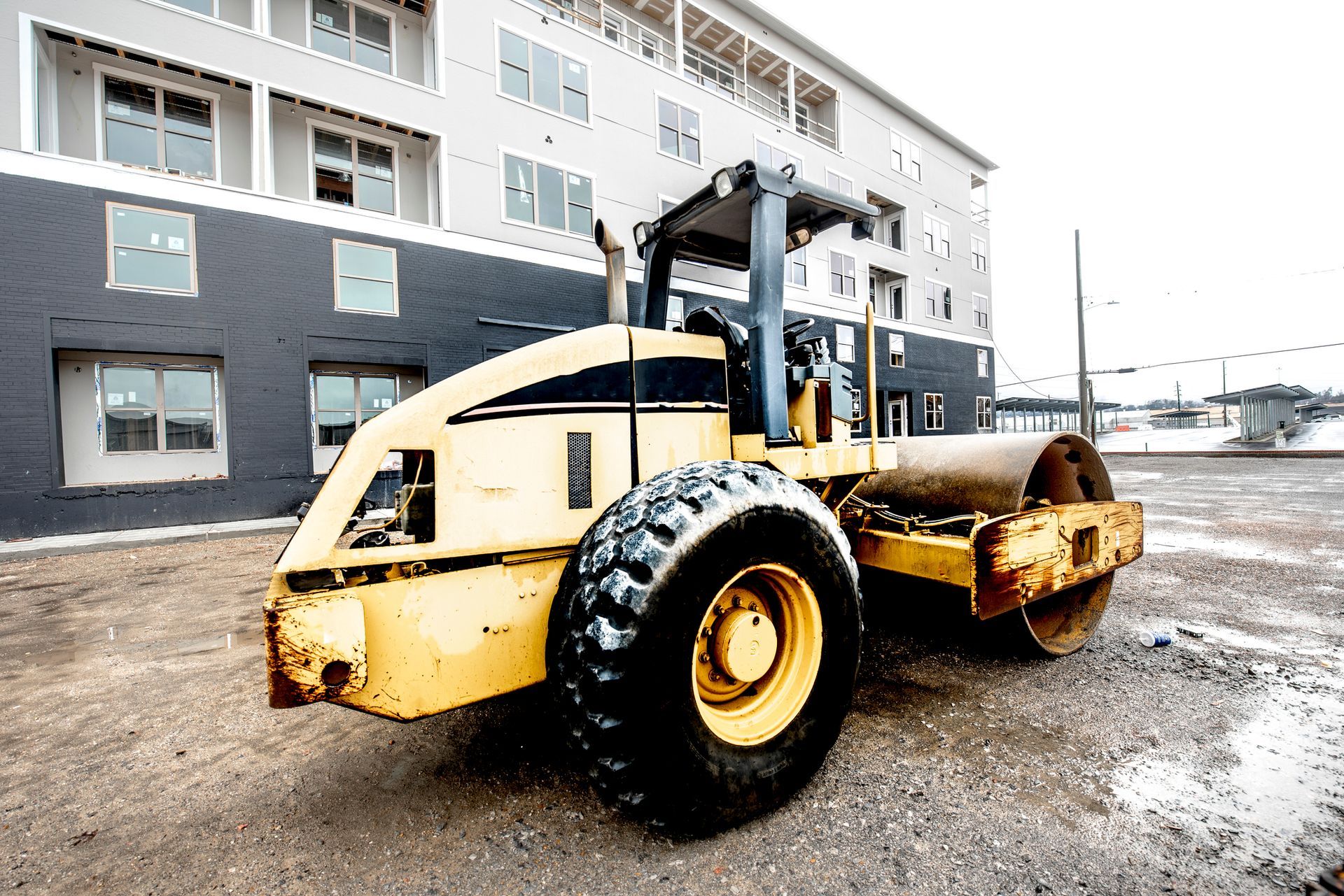 Commercial paving contractor working on asphalt paving for a multi-family building parking lot.