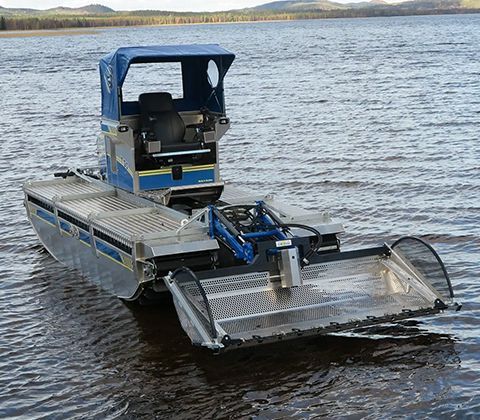 A large, amphibious boat with a front mowing attachment operates on a lake.