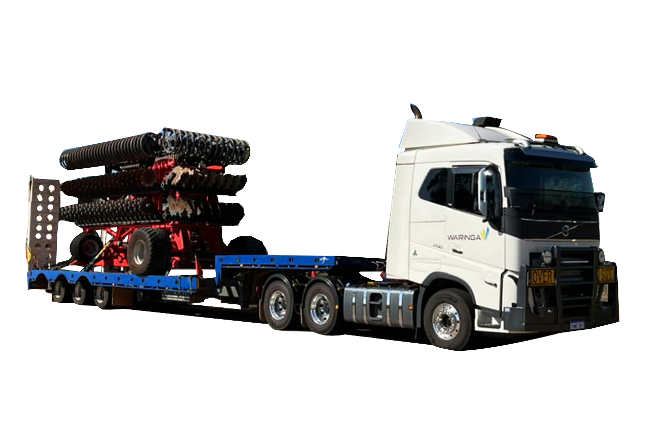 A white semi truck is carrying a trailer with a tractor on it