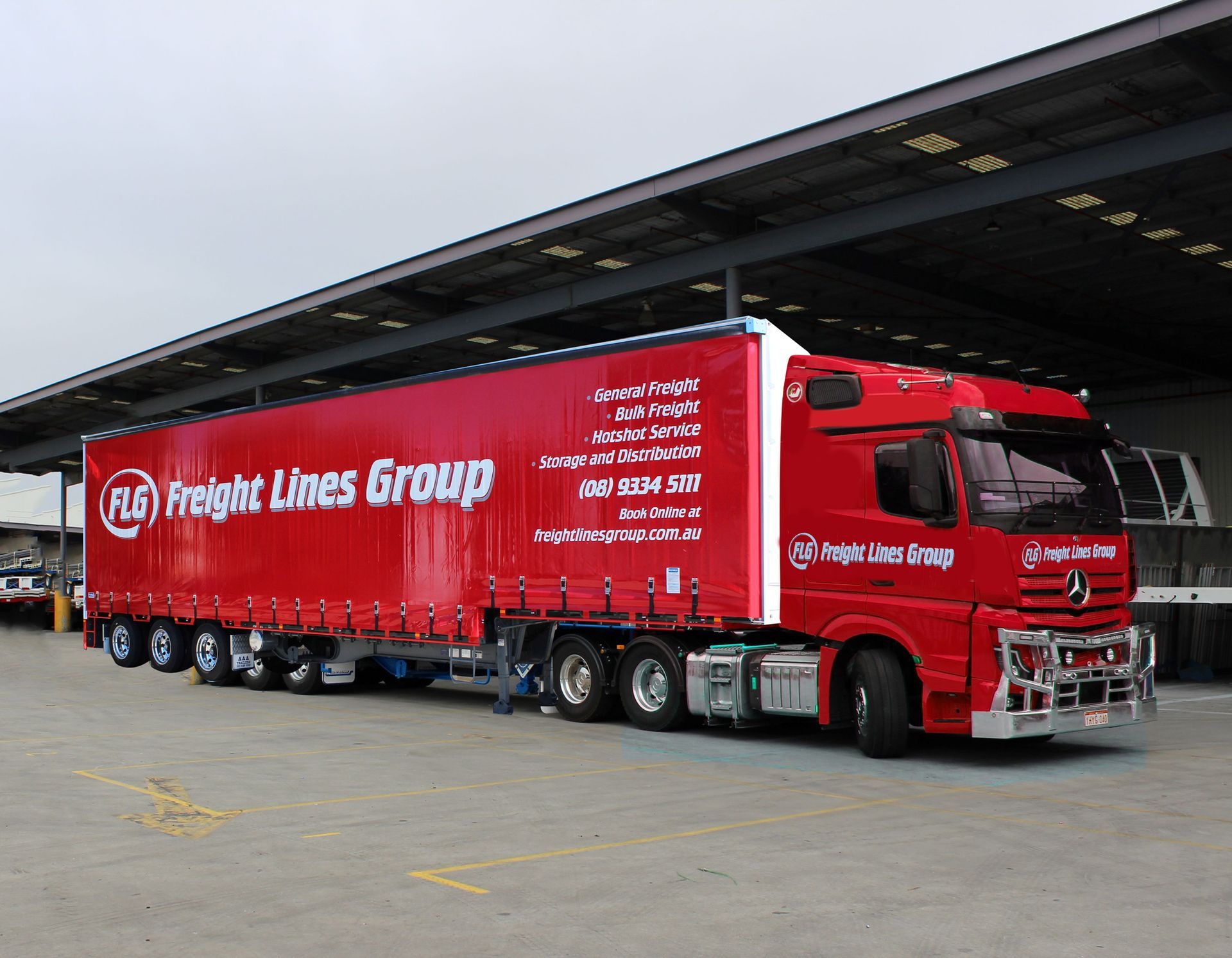 A red freight lines group truck is parked in a parking lot