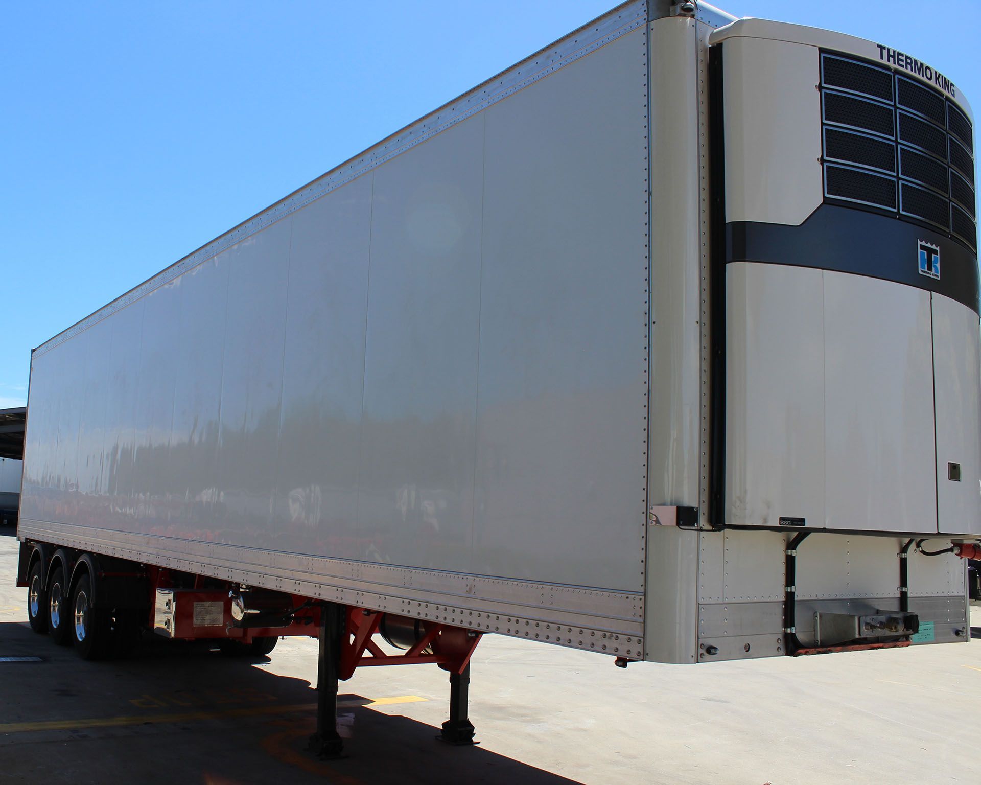 A white semi truck is parked in a parking lot.