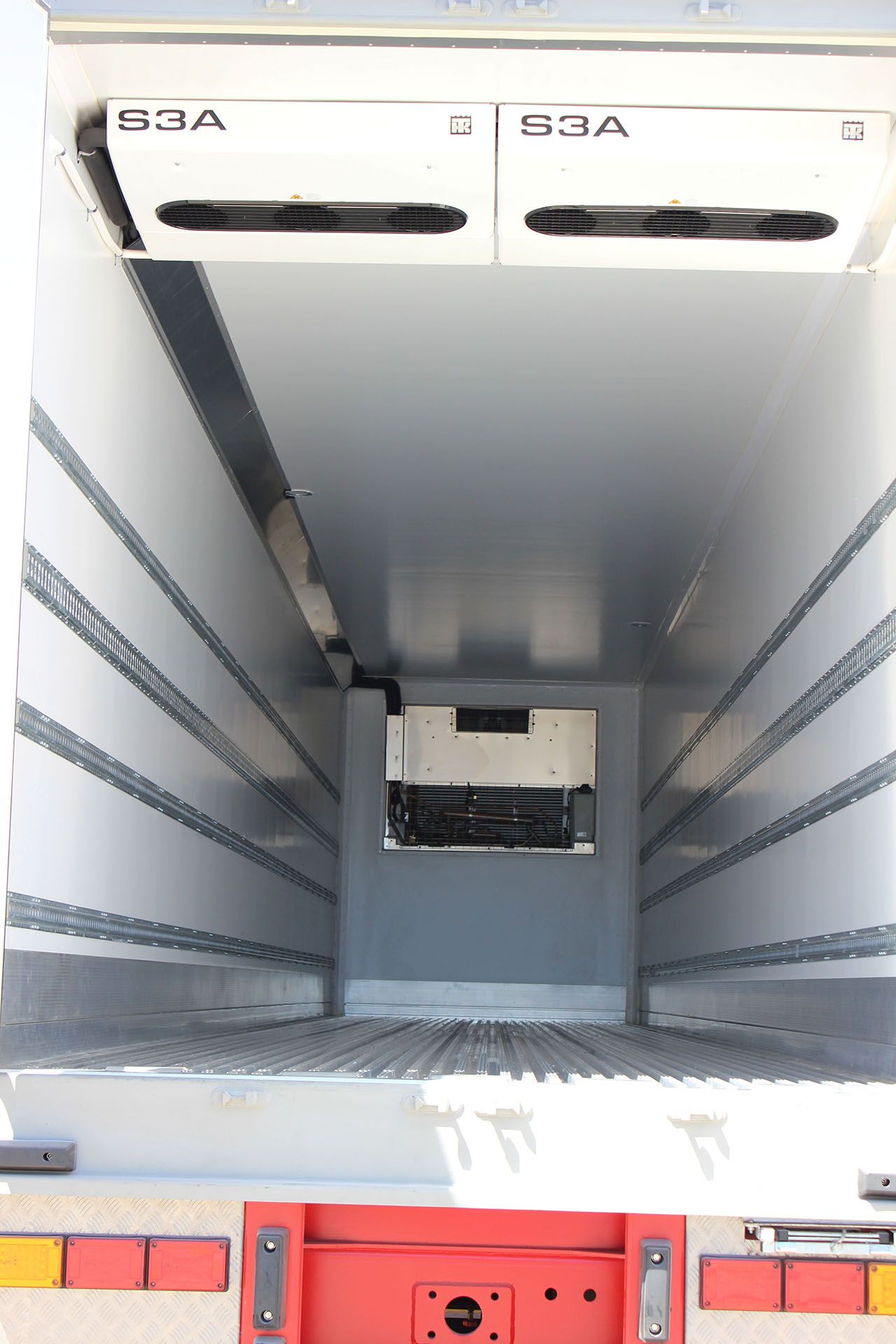 The inside of a refrigerated truck with a red tailgate