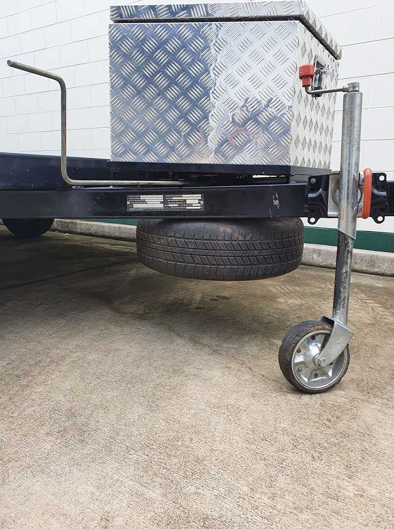 A Trailer With A Tire Attached To It Is Parked On The Side Of The Road — MTM Automotive in Bentley Park, QLD