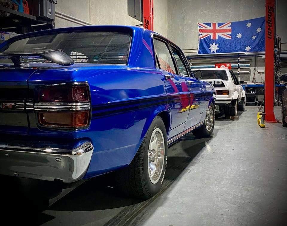 A Blue Car Is Parked In A Garage Next To A British Flag — MTM Automotive in Bentley Park, QLD