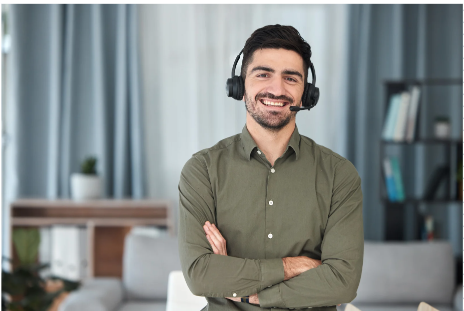 Picture of male smiling with headset on and arms crossed 