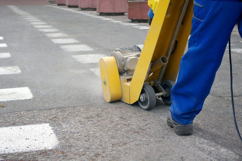 Workers adding and removing thermoplastic line markings
