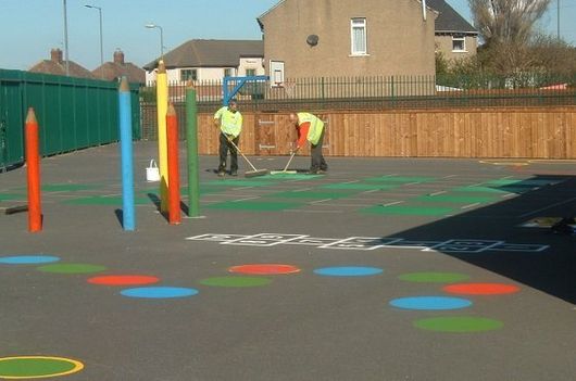 Line markers adding paint to a playground