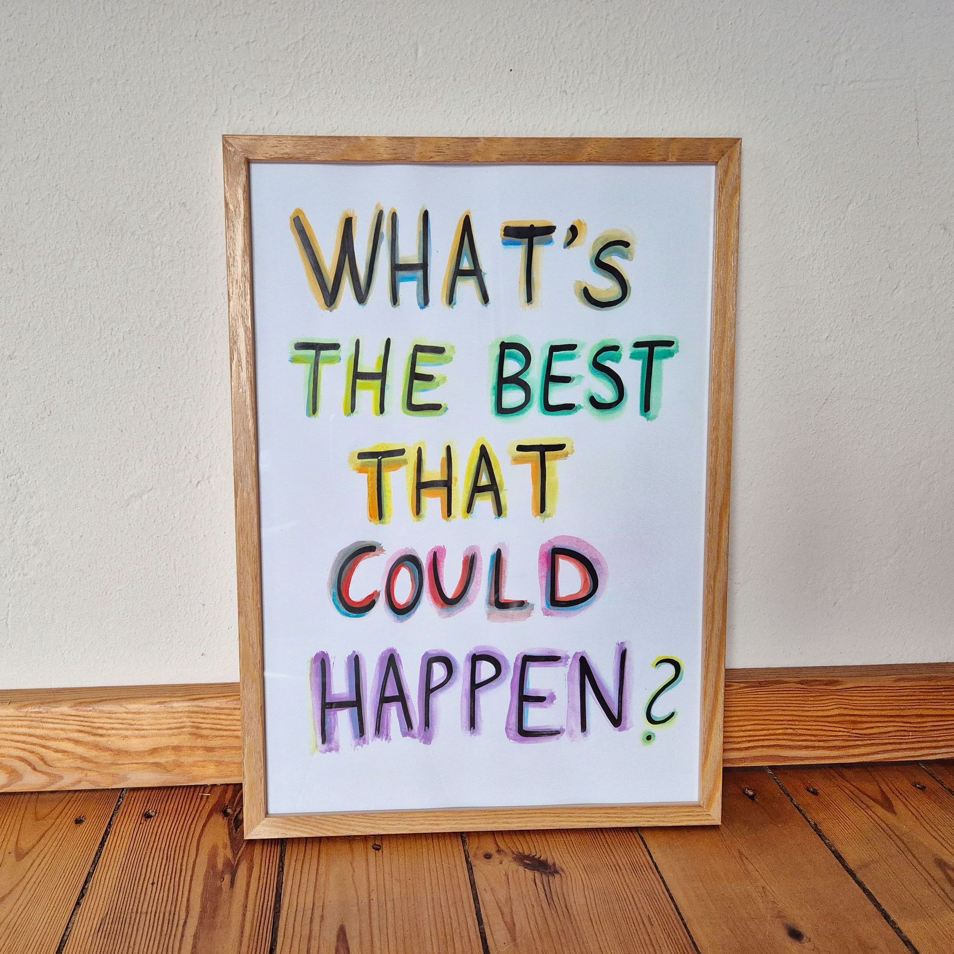 Eine Person tippt an einem Laptop an einem blauen Schreibtisch; im Hintergrund ist ein Bücherstapel zu sehen.