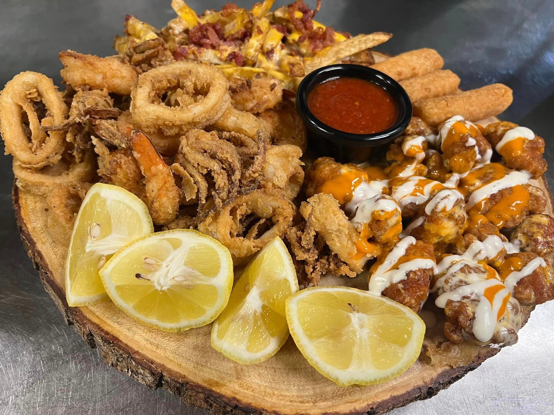 A wooden cutting board topped with fried food and lemon slices.