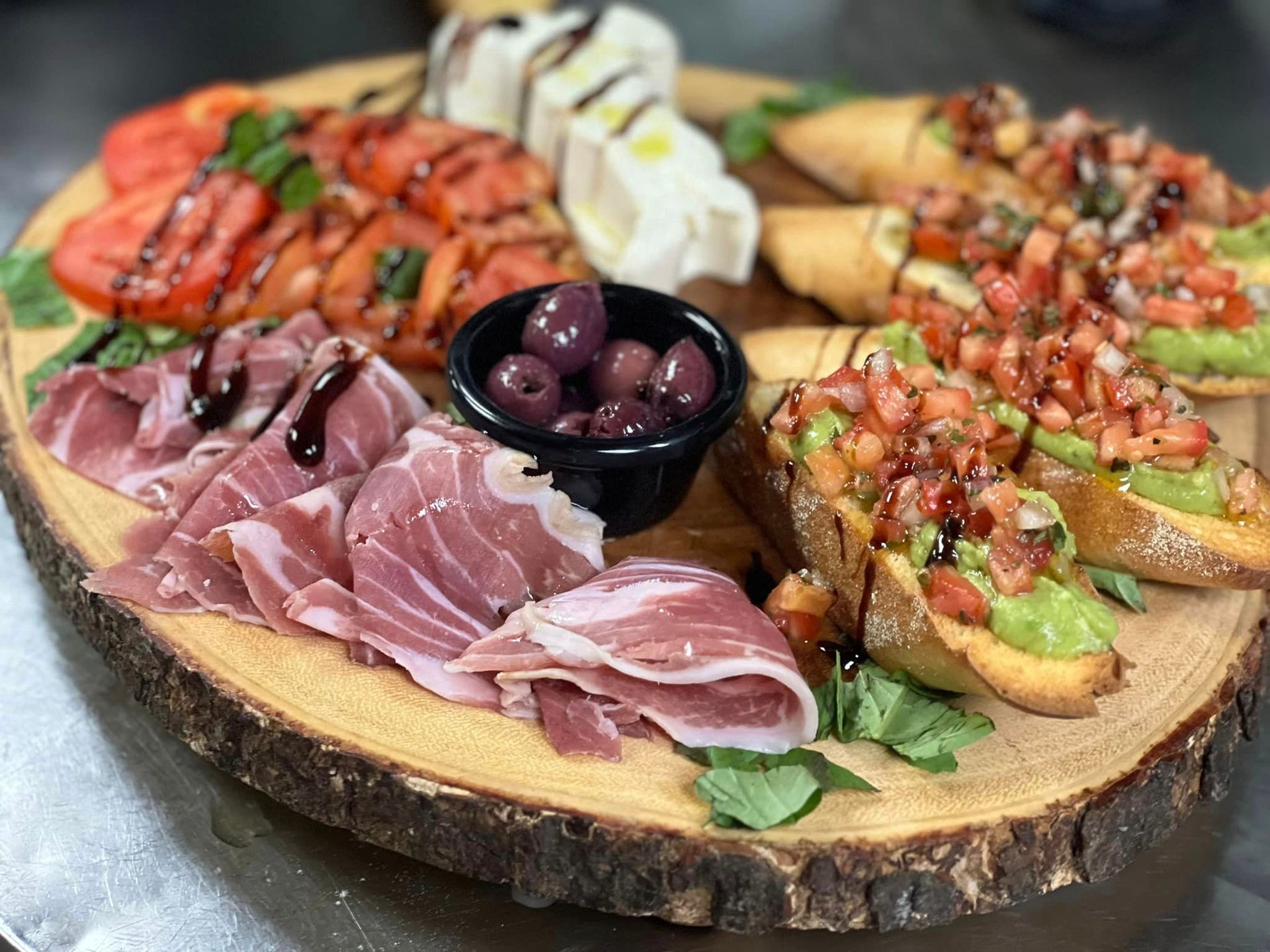 A wooden cutting board topped with a variety of meats and vegetables.