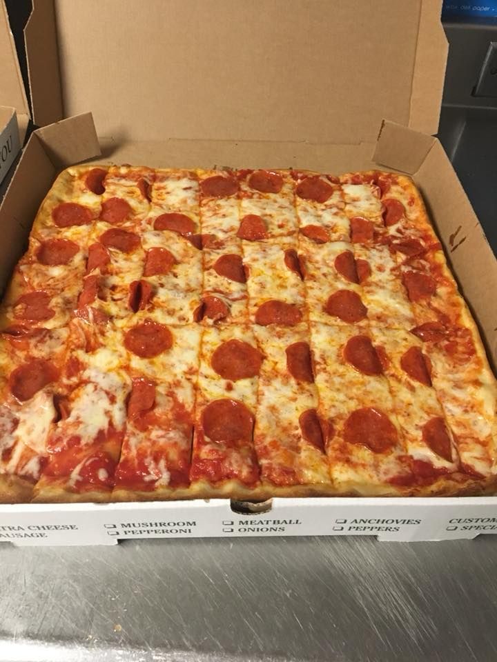 A square pepperoni pizza is in a cardboard box.