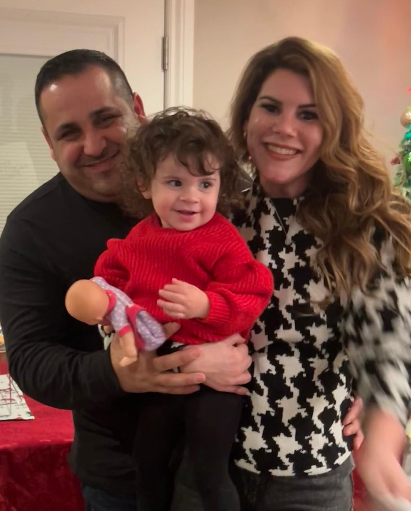 A man and woman are holding a little girl in their arms