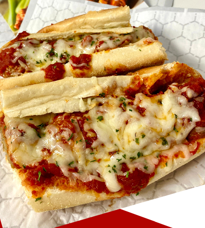 A close up of a sub sandwich with tomato sauce and cheese