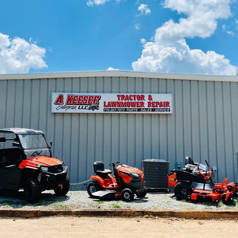 Several lawn mowers are parked in front of a building that says tractor and lawnmower repair
