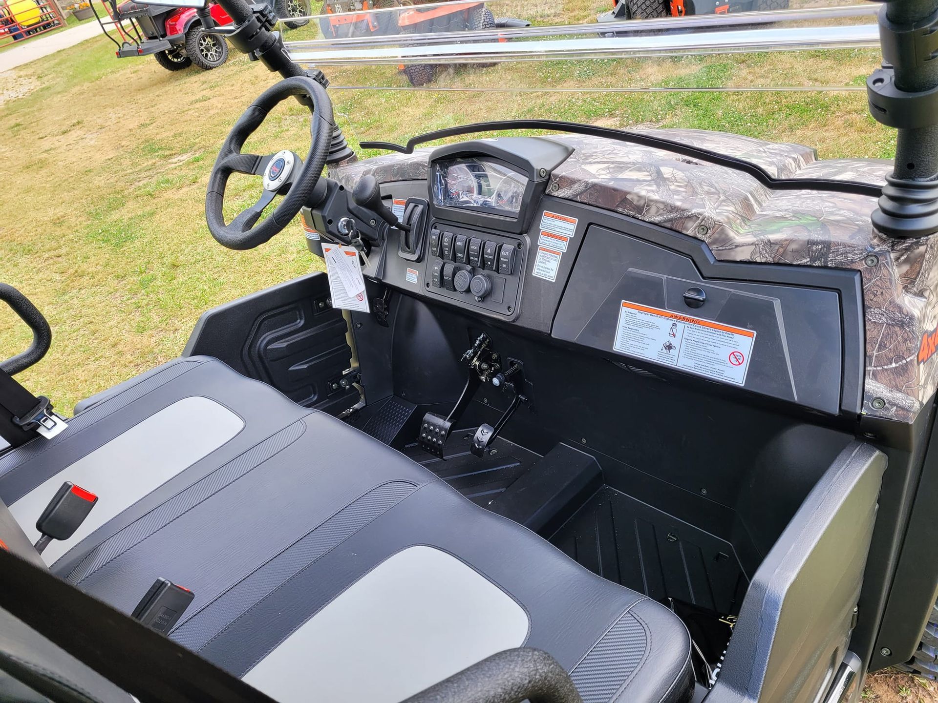 The interior of a utility vehicle is shown with a steering wheel and dashboard.
