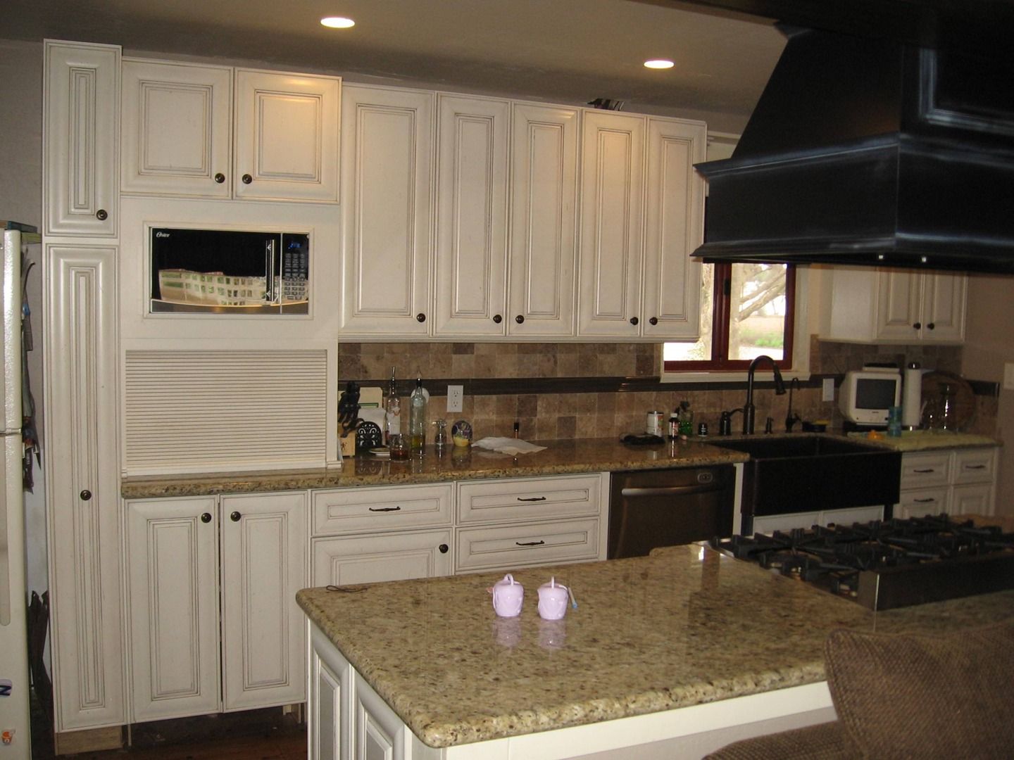 A kitchen with white cabinets and granite counter tops