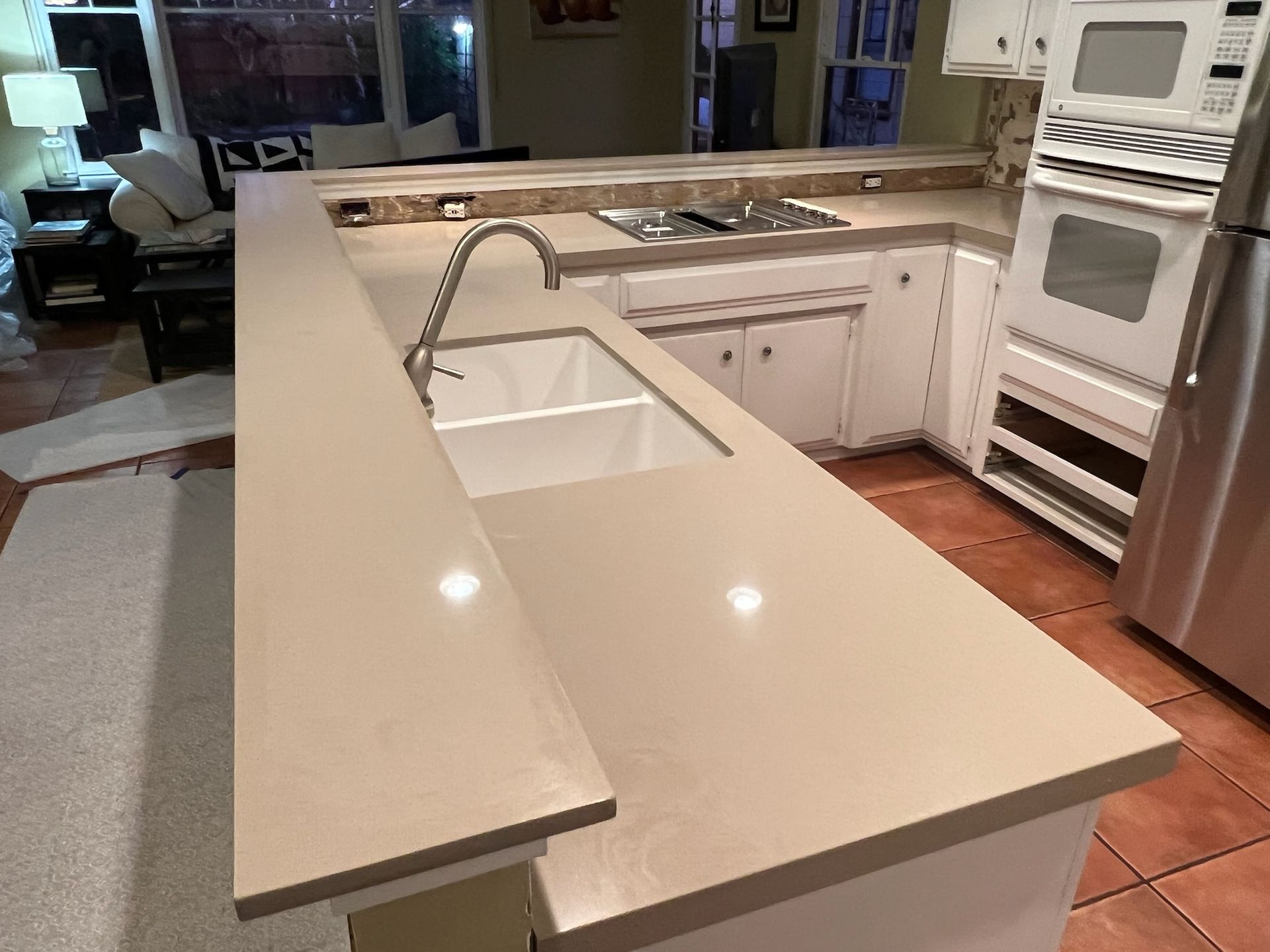 A kitchen with a sink , stove , refrigerator and microwave.