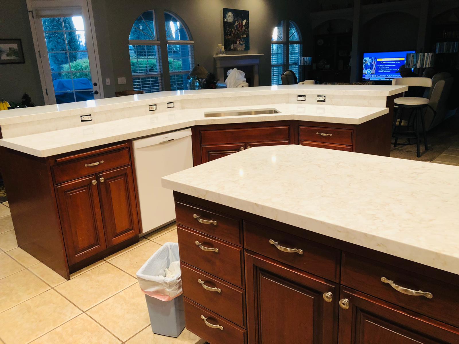 A kitchen with wooden cabinets and white counter tops