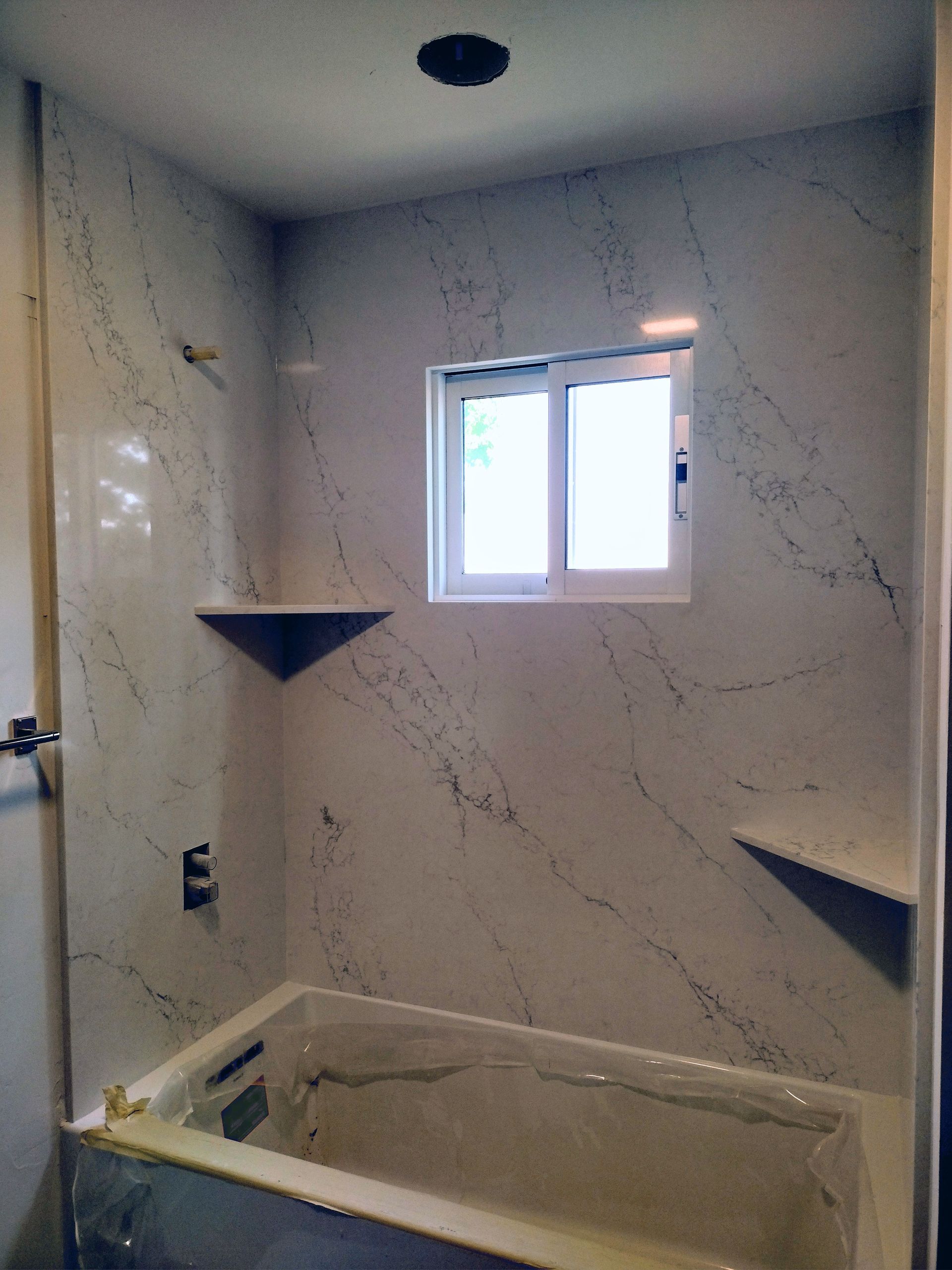 A bathroom with a bathtub and a window