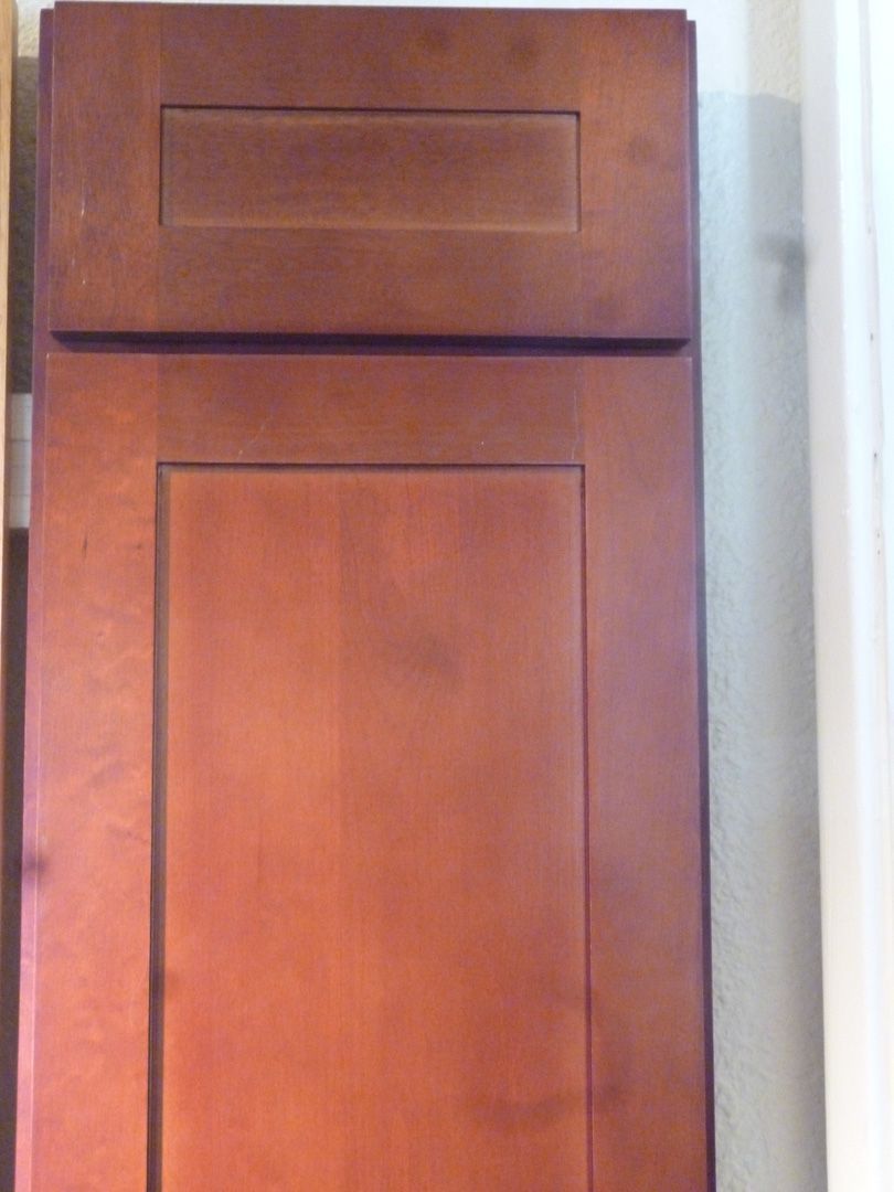 A close up of a wooden cabinet door in a kitchen.
