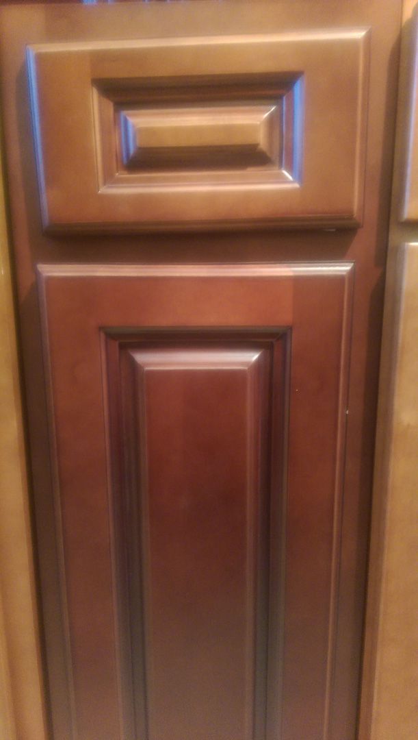 A close up of a wooden cabinet door in a kitchen.