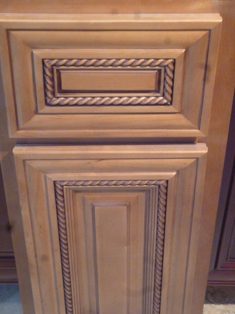 A close up of a mocha glaze wooden cabinet door with a rope design