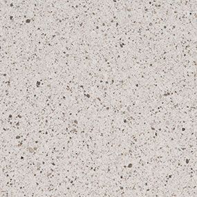 A close up of a white granite counter top with black spots.