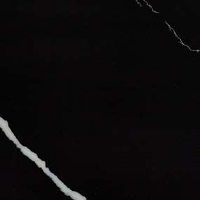 A close up of a black marble tile with a white line on it.