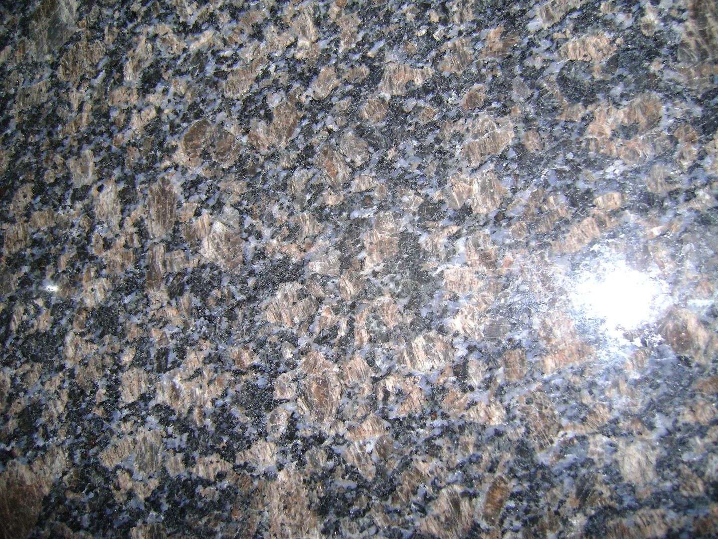A close up of a black and brown granite counter top
