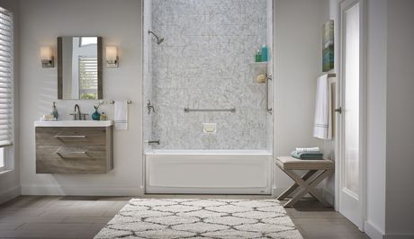 A Bathroom with A Bathtub , Sink , Mirror and Rug.