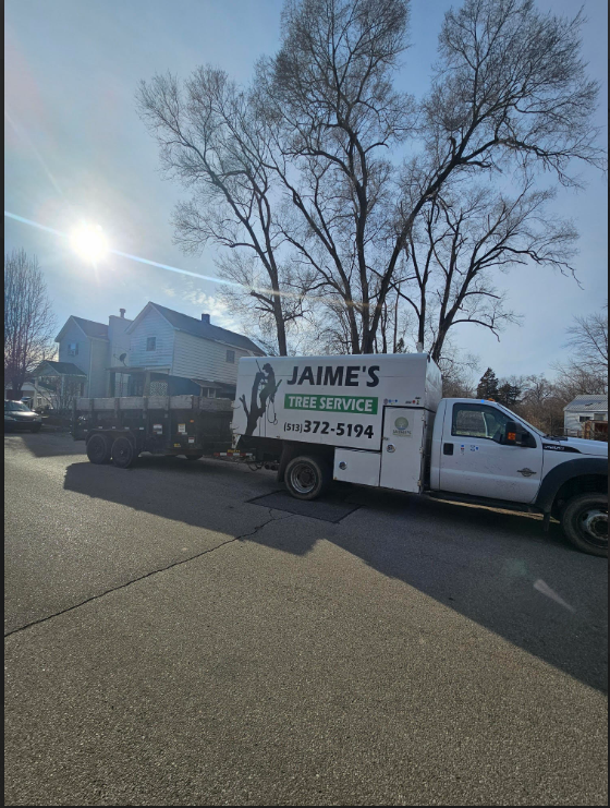 A white service truck with a utility bed and trailer parked on a street, marked