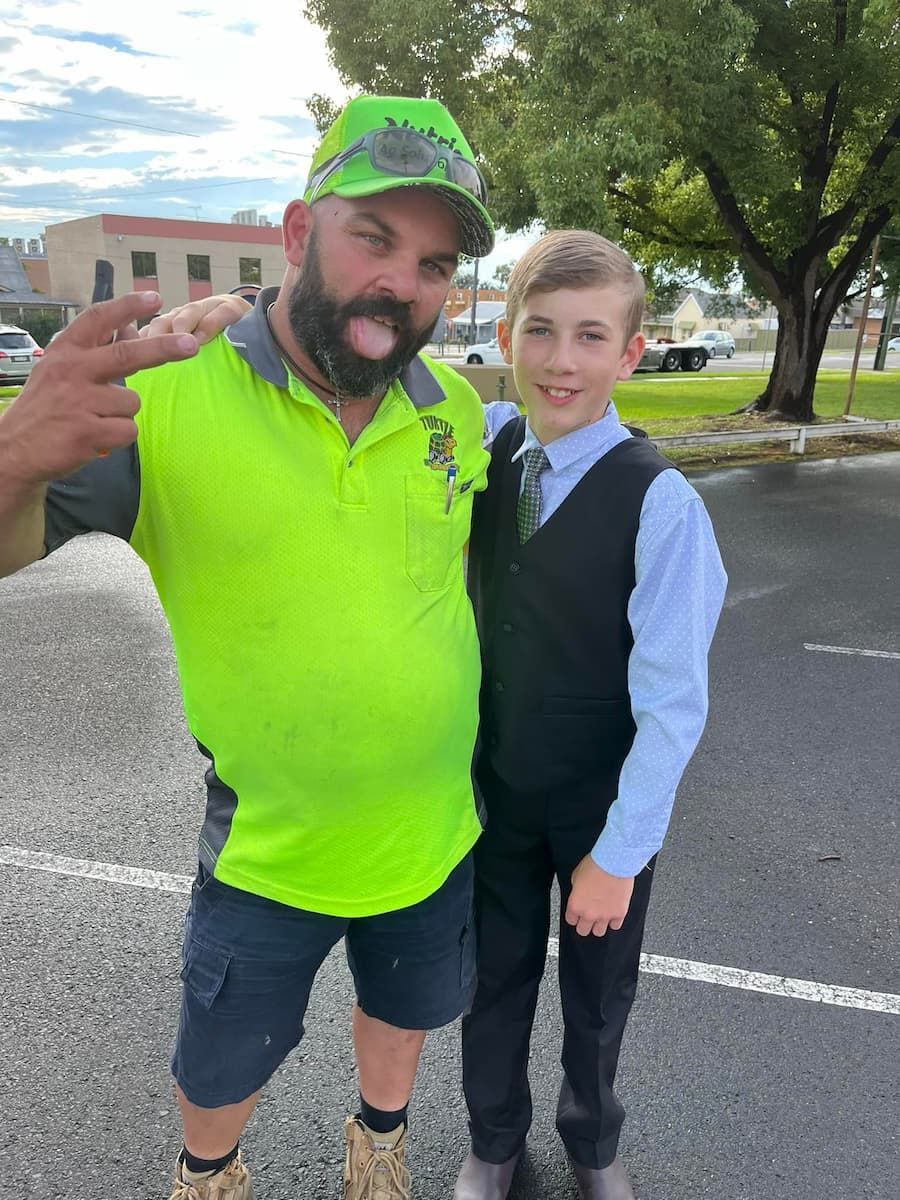Man in a Neon Green Shirt is Standing Next to a Boy in a Suit - Turtle Couriers in Tamworth, NSW