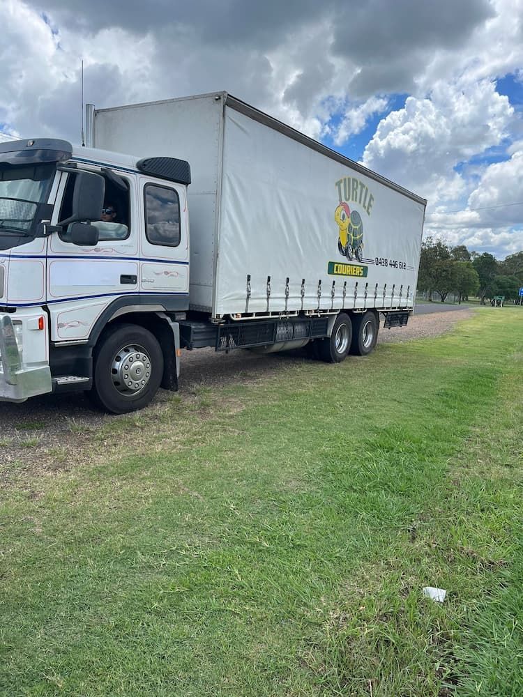 Large White Truck is Parked in a Grassy Field - Turtle Couriers in Tamworth, NSW