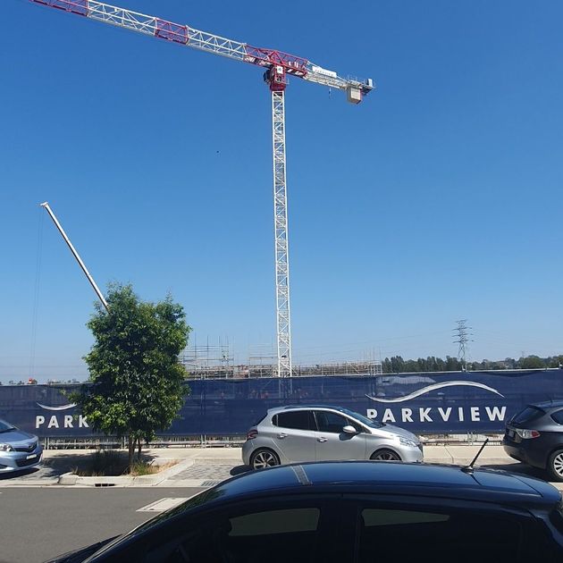 greenarrow image of construction on a sunny day with crane in foreground 