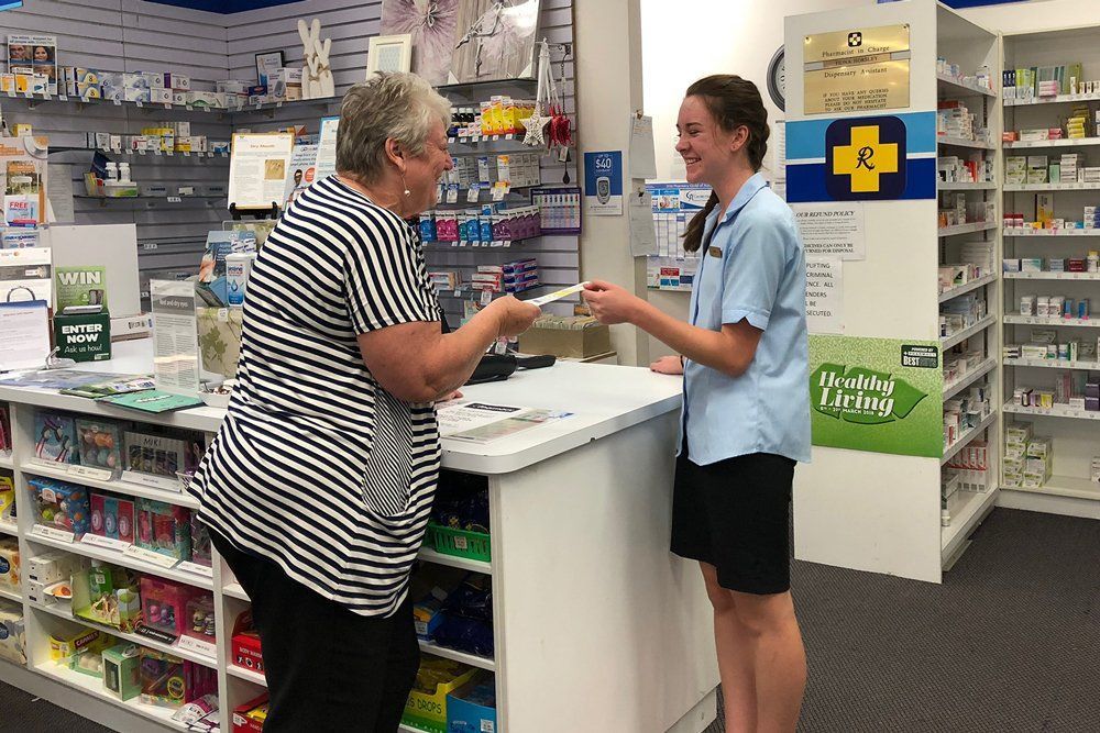 A woman is talking to a pharmacist in a pharmacy.