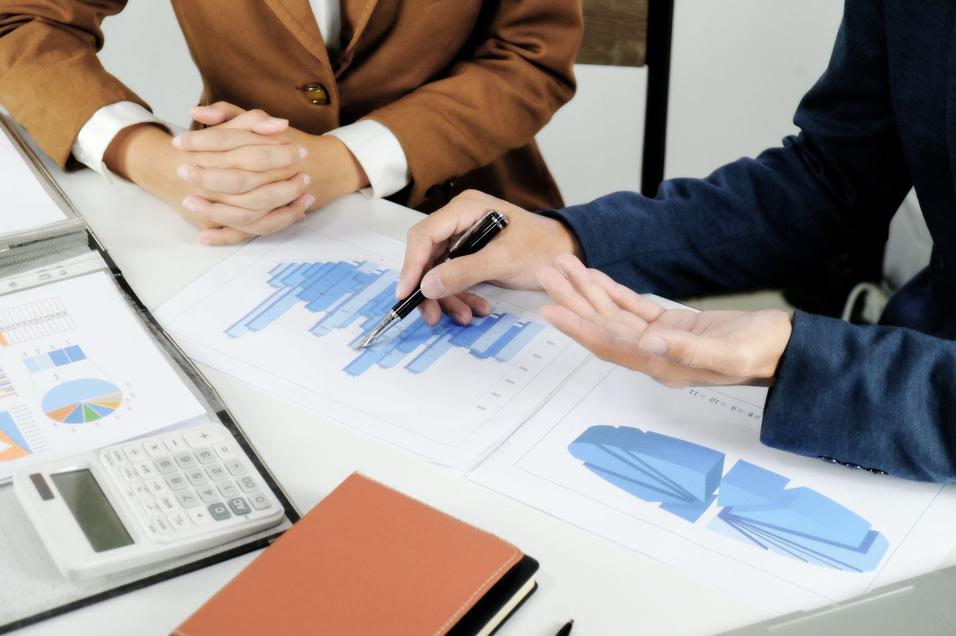 Two people reviewing charts and graphs at a desk
