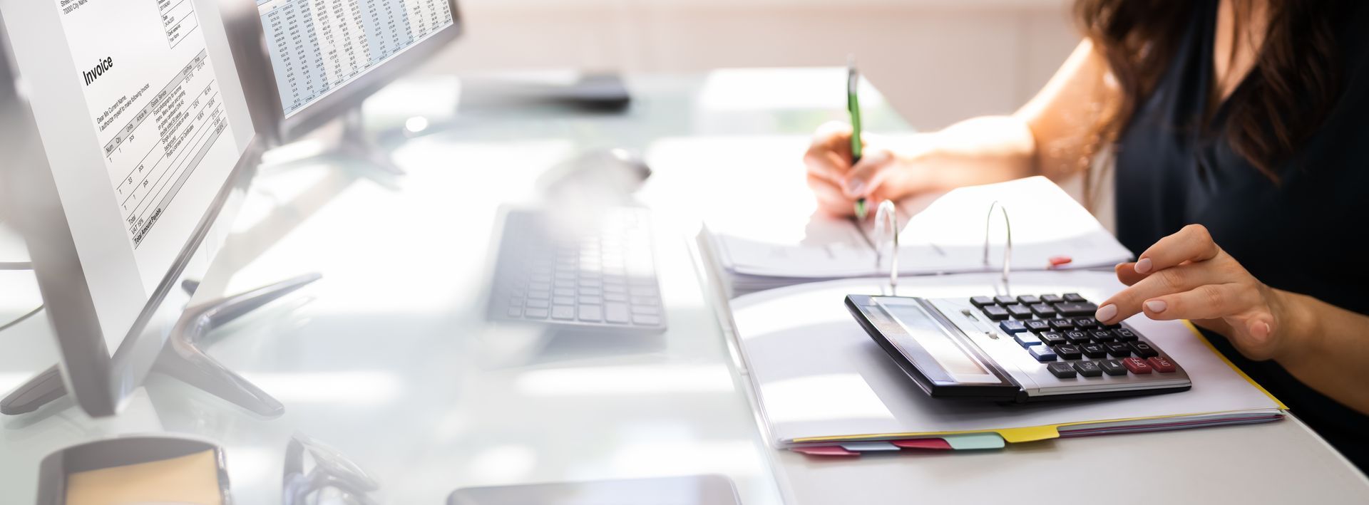 Woman calculating with calculator at desk