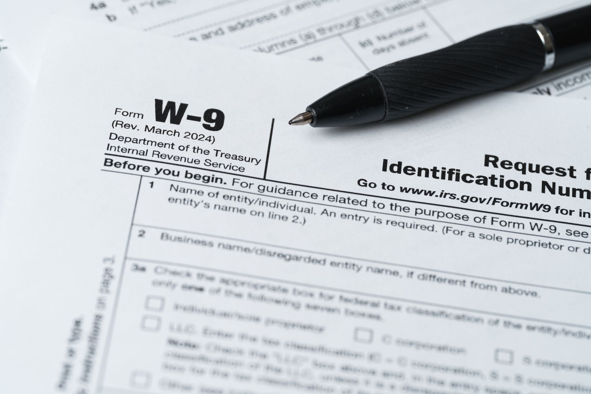 W-9 tax form with a pen on top