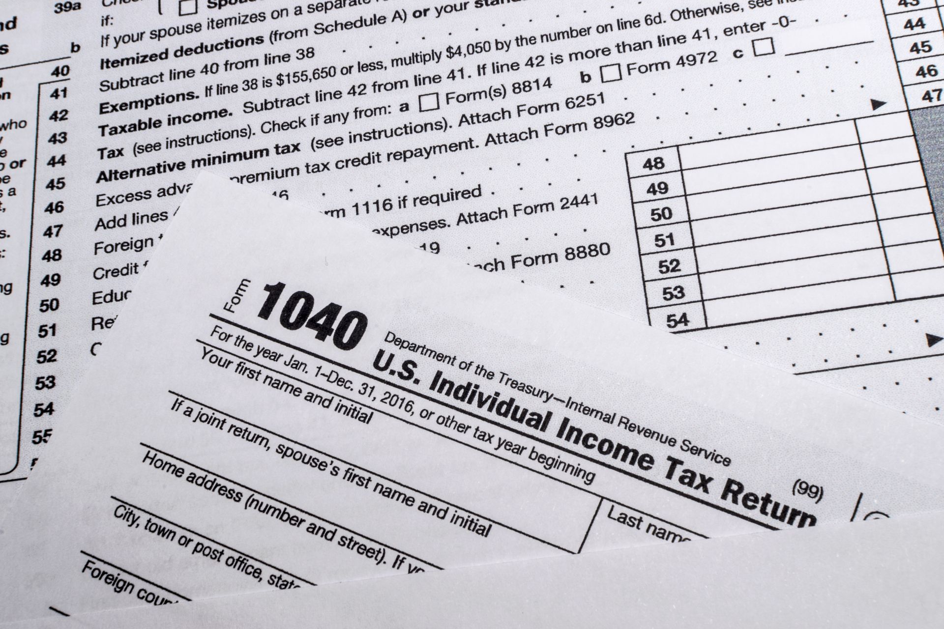 A tax form 1040 is open, with a section of instructions partially visible in the background.