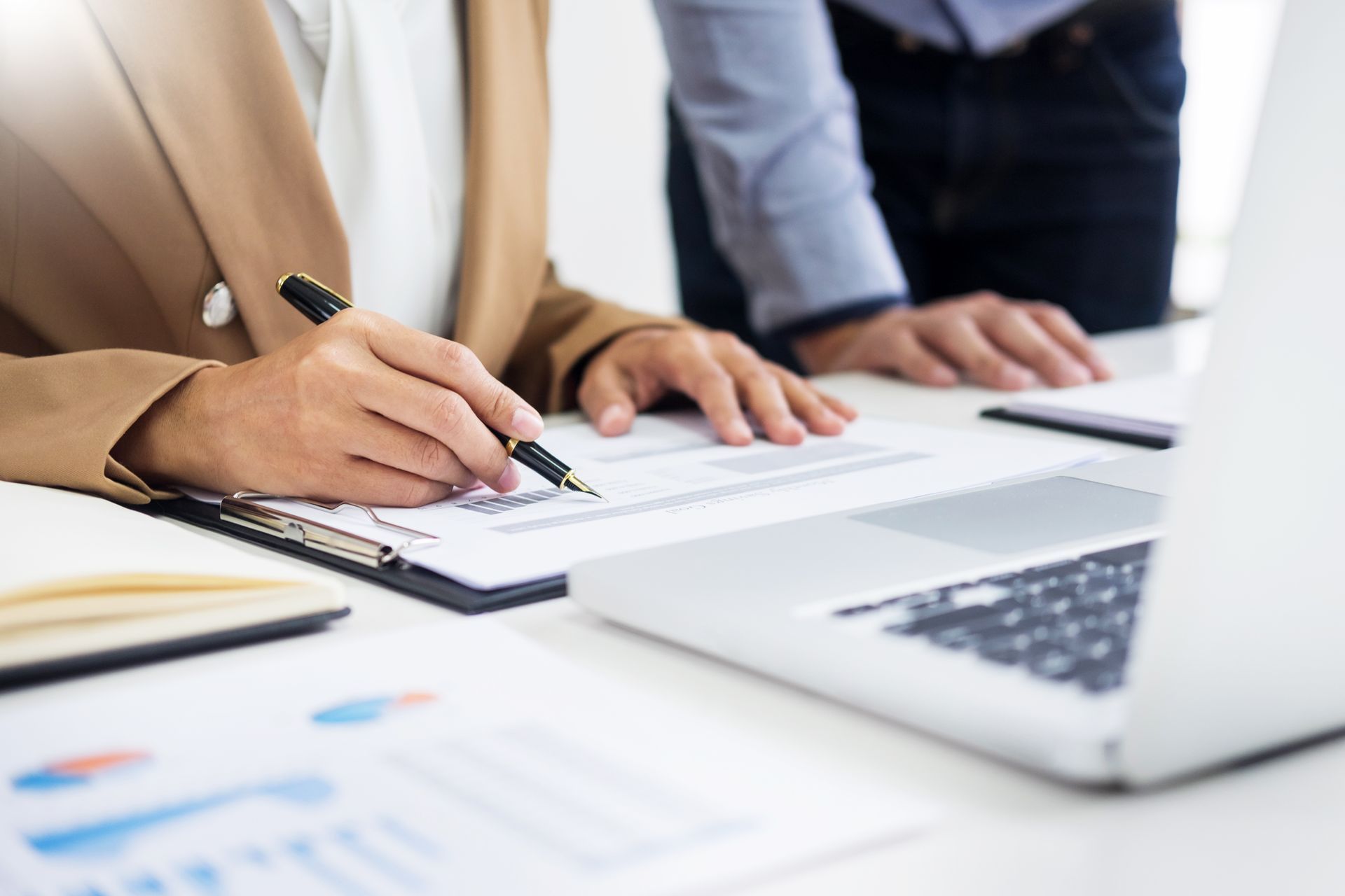 Person writing on paper with pen