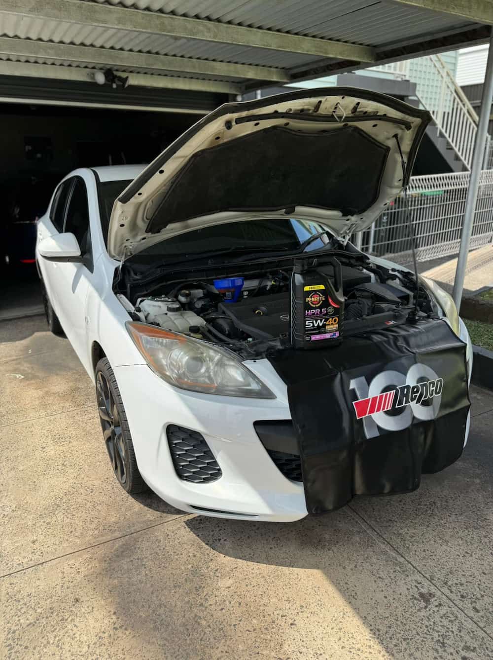 A White Car with The Hood up Is Parked in A Garage — BEB Automotive In Berkeley, NSW